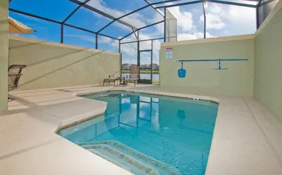 a swimming pool in a house with a glass ceiling at Beautiful Waterfront Townhome Wsplashpool-3024 in Kissimmee