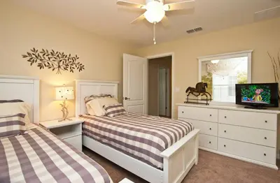 a bedroom with two beds and a flat screen tv at Beautiful Waterfront Townhome Wsplashpool-3024 in Kissimmee