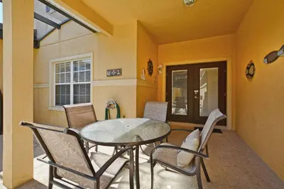 a dining room with a glass table and chairs at Pvt Splashpool, Bbq Grill, Close To Parks-3057Pp in Kissimmee