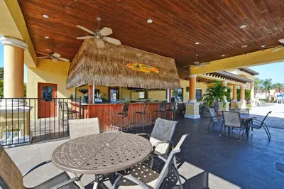 a patio with a table and chairs and a bar at Pvt Splashpool, Bbq Grill, Close To Parks-3057Pp in Kissimmee