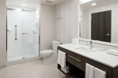 a bathroom with a toilet and a sink and a shower at Home2 Suites By Hilton Orlando Airport in Orlando