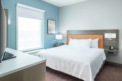 a hotel room with a bed and a window at Home2 Suites By Hilton Orlando Airport in Orlando