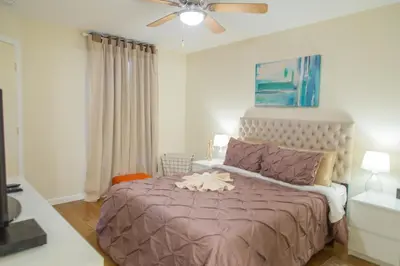 a bedroom with a large bed with a ceiling fan at Disney Adjacent in Kissimmee