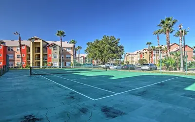 a tennis court at a apartment complex with palm trees at Disney Adjacent in Kissimmee