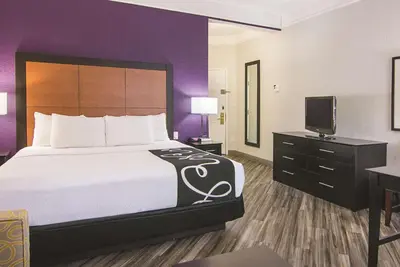 a hotel room with a bed and a tv at La Quinta by Wyndham Orlando Airport - On Property Food Trucks & Free Airport Shuttle! in Orlando