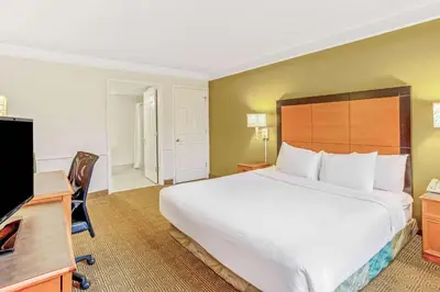a hotel room with a bed and a desk and a television at La Quinta Inn by Wyndham Orlando Airport West in Orlando