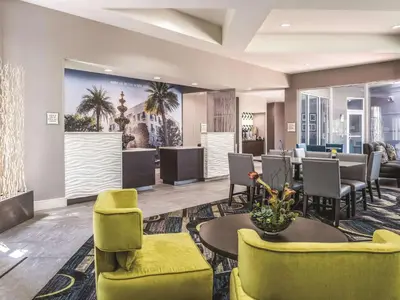 a lobby with a waiting area with chairs and tables at La Quinta by Wyndham Orlando Lake Mary in Lake Mary