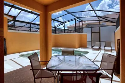 a room with a table and chairs in a building at South Facing Pool Wsplashpool- 3080Pp in Kissimmee