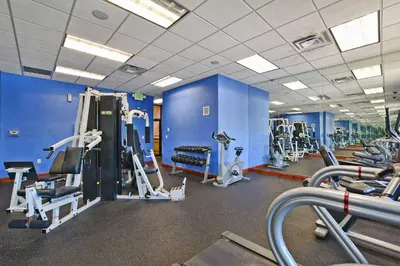 a gym with blue walls and tread machines at South Facing Pool Wsplashpool- 3080Pp in Kissimmee