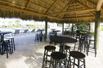 a group of tables and chairs under a straw roof at Perfect Townhome for your Vacation with Private Pool SL4807 in Kissimmee