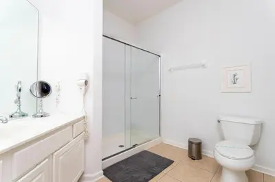 a bathroom with a toilet and a glass shower at Gorgeous Apartment in Orlando at Vista Cay Resort in Orlando