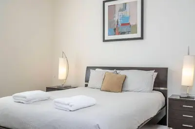 a bedroom with a white bed with two lamps at Wonderful Apt Convention Center VistaCay VC50253 in Orlando