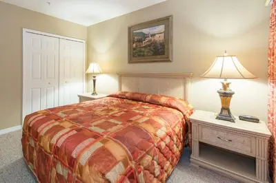 a bedroom with a bed and two tables and a lamp at WQR Private Rentals No Resort Pool Access in Orlando