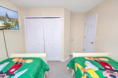 a bedroom with two beds and a painting on the wall at Disney Dream with Hot Tub, Pool, Xbox, Games Room, Lakeview, 10 min to Disney, Clubhouse in Kissimmee