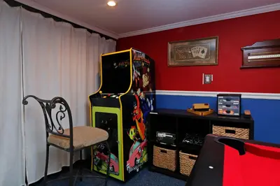 a room with a video game machine and a chair at Seasons Villa 6 bedrooms, 4 masters and water view in Kissimmee