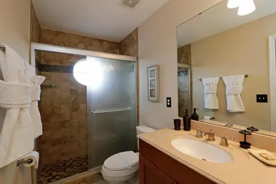 a bathroom with a shower and a sink and a toilet at Seasons Villa 6 bedrooms, 4 masters and water view in Kissimmee