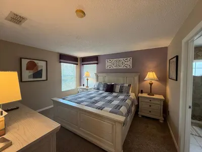 a bedroom with a bed and two night stands and two lamps at Seasons Villa 6 bedrooms, 4 masters and water view in Kissimmee