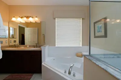a bathroom with a tub and a shower and a sink at The Villa at Terra Verde in Kissimmee