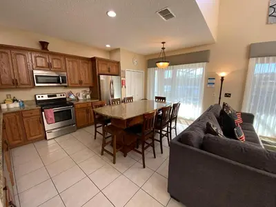 a living room with a couch and a kitchen with a table at The Villa at Terra Verde in Kissimmee