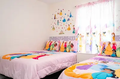 a bedroom with two beds and a wall with disney stickers at Stunning 5 Bd Home w/ Pool Close to Disney 4822 in Kissimmee
