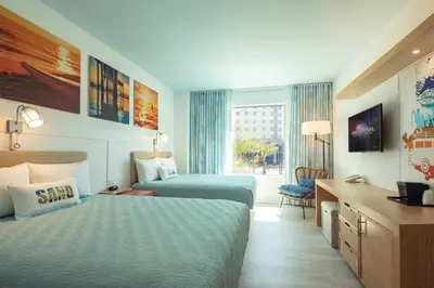 a hotel room with two beds and a desk at Universal’s Endless Summer Resort – Dockside Inn and Suites in Orlando