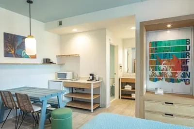 a kitchen and living room with a table and chairs at Universal’s Endless Summer Resort – Dockside Inn and Suites in Orlando