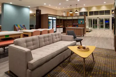 a living room with a couch and a table at Holiday Inn & Suites Orlando - I-Drive - Theme Parks by IHG in Orlando