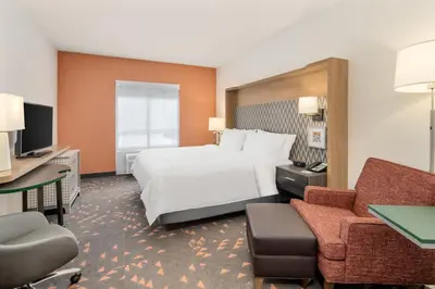 a hotel room with a bed and a desk and chair at Holiday Inn & Suites Orlando - I-Drive - Theme Parks by IHG in Orlando