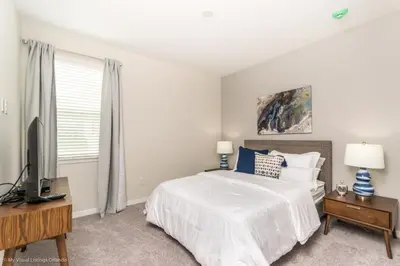 a white bedroom with a bed and a television at Sunshine Ridge Loop Villa #258891 Villa in Orlando
