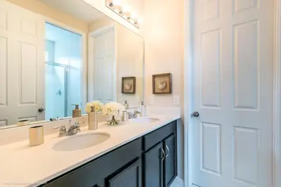 a bathroom with two sinks and a large mirror at Sunshine Ridge Loop Villa #258891 Villa in Orlando