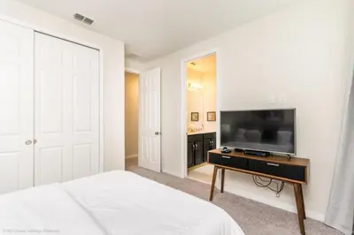 a bedroom with a bed and a flat screen tv at Sunshine Ridge Loop Villa #258891 Villa in Orlando