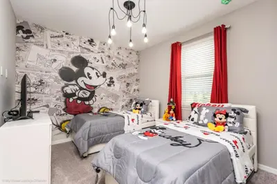 a bedroom with two beds with mickey mouse wallpaper at Sunshine Ridge Loop Villa #258891 Villa in Orlando
