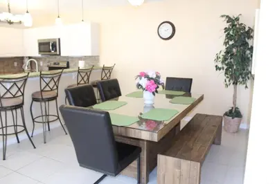 a dining room table with a vase of flowers on it at Lindfields Reserve #267170 Villa in Kissimmee