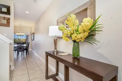 a vase of yellow flowers on a table in a hallway at Cuban Palm Townhouse #275805 Townhouse in Kissimmee