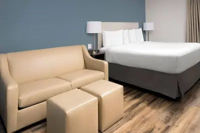 a hotel room with a bed and a couch at Woodspring Suites Orlando International Drive in Orlando