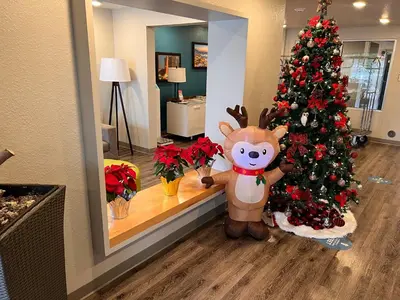 a reindeer standing next to a christmas tree at Woodspring Suites Orlando International Drive in Orlando