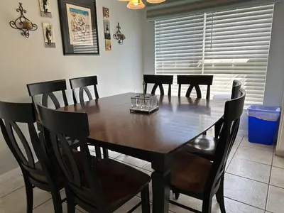 a dining room with a wooden table and chairs at House By the Mouse in Kissimmee