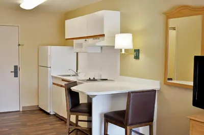 a small kitchen with a white counter and chairs at Extended Stay America Suites - Orlando - Altamonte Springs in Orlando