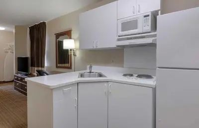 a kitchen with white cabinets and a sink and a microwave at Extended Stay America Suites - Orlando - Lake Mary - 1036 Greenwood Blvd in Lake Mary