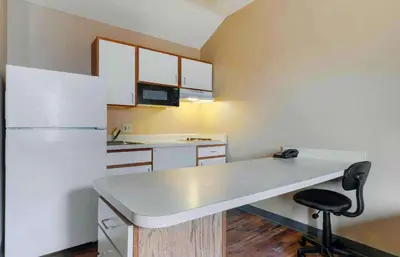 a kitchen with a white counter and a refrigerator at Extended Stay America Select Suites - Orlando - Lake Mary - 1040 Greenwood Blvd in Lake Mary