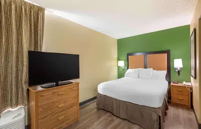 a hotel room with a bed and a flat screen tv at Extended Stay America Select Suites - Orlando - Lake Mary - 1040 Greenwood Blvd in Lake Mary