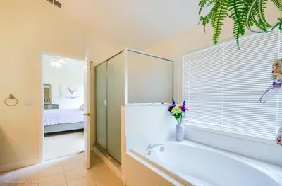 a bathroom with a bath tub and a bedroom at Cinderellas Castle in Kissimmee