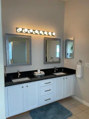 a bathroom with two sinks and two mirrors at Cinderellas Castle in Kissimmee