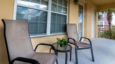 two chairs and a table on a porch at Merlyns Magic Condo - closer to Disney in Orlando