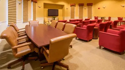 a conference room with a wooden table and red chairs at Merlyns Magic Condo - closer to Disney in Orlando
