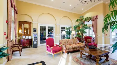 a living room with a couch and chairs and a table at Merlyns Magic Condo - closer to Disney in Orlando