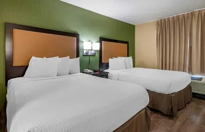 a hotel room with two beds and a window at Extended Stay America Suites - Orlando - Orlando Theme Parks - Major Blvd in Orlando