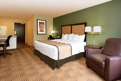 a bedroom with a bed and a desk and a chair at Extended Stay America Select Suites - Orlando - Maitland - 1760 Pembrook Dr in Orlando