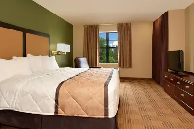 a hotel room with a bed and a television at Extended Stay America Select Suites - Orlando - Maitland - 1760 Pembrook Dr in Orlando
