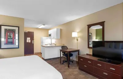 a hotel room with a bed and a desk and a kitchen at Extended Stay America Suites - Orlando - Maitland - 1776 Pembrook Dr in Orlando